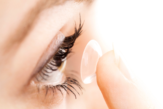 Kobieta zakłada soczewkę.